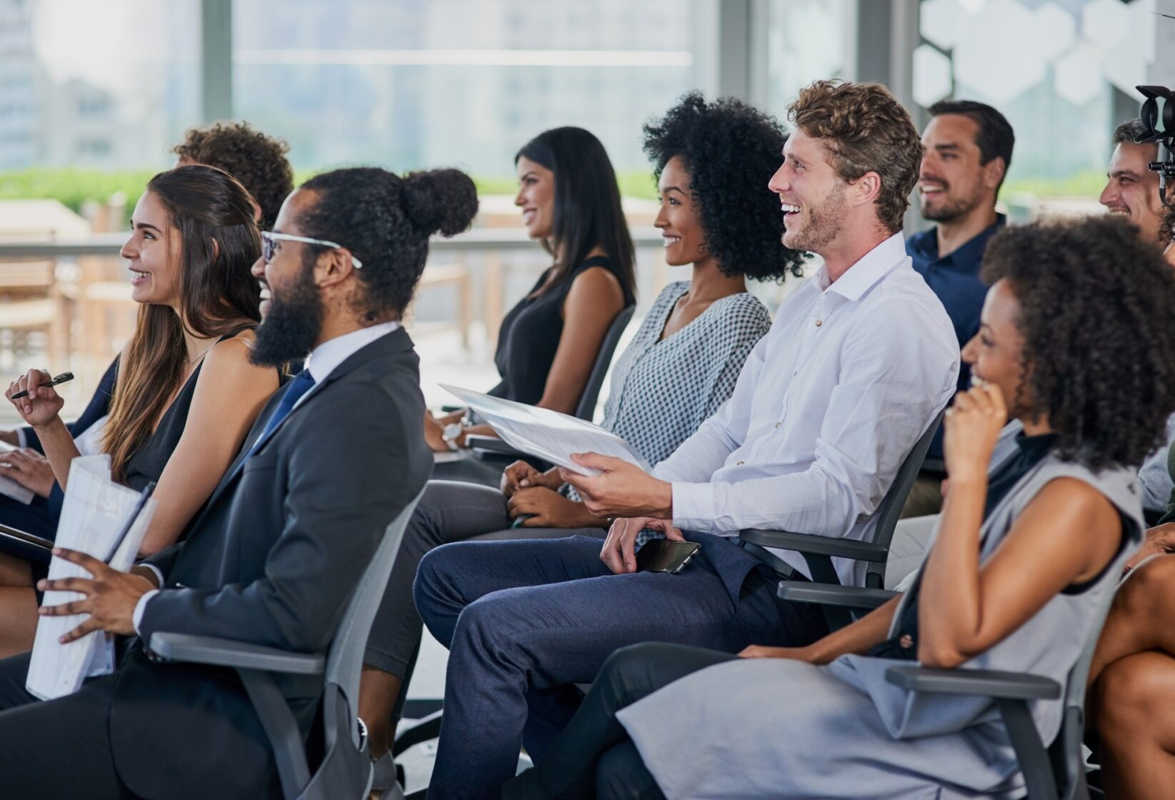 People sat in theatre style engaged in a presentation